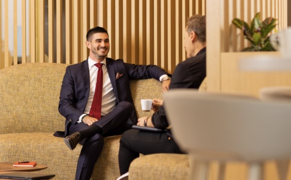 Two men having a casual conversation in the office lobby