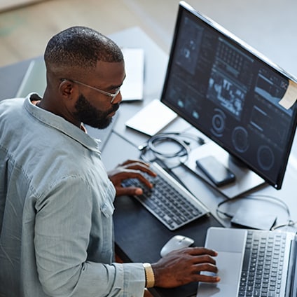 Man working on two computers