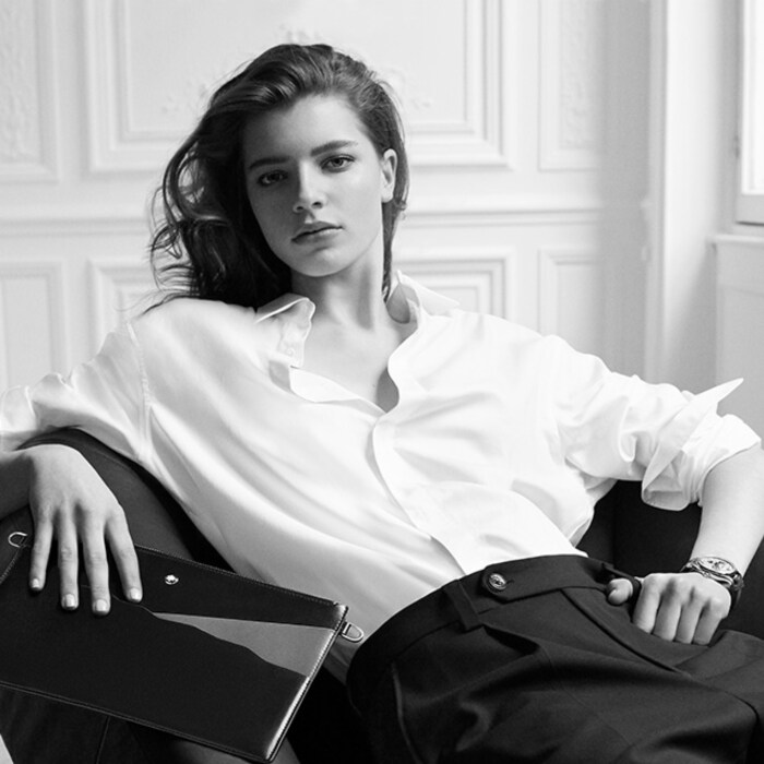 Woman on a lounge holding a leather pouch